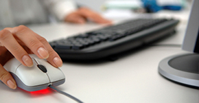 Photo of hands and on a mouse and keyboard